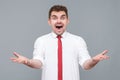 man standing with shocked face, open mouth and raised arms looking at camera Royalty Free Stock Photo