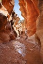 Man standing in a slot canyon and looking upward