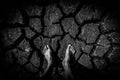 Man standing on soil dry land cracked ground surface. Black landscape dried and cracked background. dark drama concept