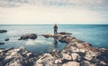 Man standing on stones at sea coast looking at horizon. Beach, ocean travel and freedom concept Royalty Free Stock Photo