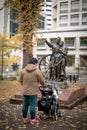 A man standing with stroller at autumn park with yellow maple Royalty Free Stock Photo