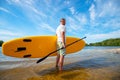 Man is standing with a SUP board and a paddle in his hands Royalty Free Stock Photo