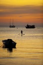 Man standing on sup ,stand up paddle board sailing in koh tao harbor against beautiful sunset sky Royalty Free Stock Photo