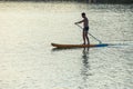 Man standing on the supboard on the middle of the lake. Royalty Free Stock Photo