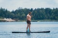 man standing on the supboard on the middle of the lake