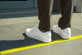 Man standing on taped floor marking for social distance outdoors. Coronavirus pandemic