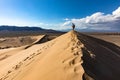 Man standing on top Beautiful sand dune blue skies in sunny day Royalty Free Stock Photo