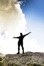 Man standing on top of a cliff with arms raised Royalty Free Stock Photo