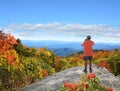 Man standing on top of the mountain taking photos Royalty Free Stock Photo