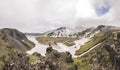 Man standing on volcanic with view on snowy volcanoes