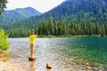 Man standing in water with feet and lokking at mountain