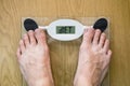 Man standing on weight scale, diet recommendation text on scale. Diet word on weight scale screen with man feet Royalty Free Stock Photo