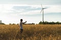 A man standing in a field looking at a wind generator Royalty Free Stock Photo