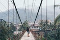 Man standing on wooden suspension bridge in a mountain village of Laos Royalty Free Stock Photo