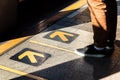 Man standing at the yellow arrow sign waiting for a public transport vehicle. Royalty Free Stock Photo