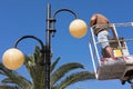 Man stands on aerial platform and replaces the lights of street lighting Royalty Free Stock Photo