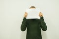 Young man stands and holds in his hands a white sheet of paper stands ÃÅ¸ÃÂ¾Ãâ¦ÃÂ¾ÃÂ¶ÃÂ¸ÃÂµ ÃÂÃÂ»ÃÂ¾ÃÂ²ÃÂ° stand