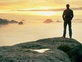 Man stands alone on the peak of rock. Hiker watching to autumn Sun at horizon . Beautiful moment the miracle of nature Royalty Free Stock Photo