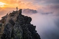 Man stands alone on the peak of rock. Hiker watching to autumn Sun at horizon . Beautiful moment the miracle of nature. Colorful Royalty Free Stock Photo