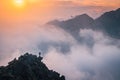 Man stands alone on the peak of rock. Hiker watching to autumn Sun at horizon . Beautiful moment the miracle of nature. Colorful Royalty Free Stock Photo