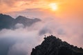 Man stands alone on the peak of rock. Hiker watching to autumn Sun at horizon . Beautiful moment the miracle of nature. Colorful Royalty Free Stock Photo