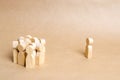 The man stands aside and looks at the crowd of people on a beige paper background. The concept of cohesion and cooperation.