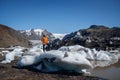 Man stands on a background of glacier, icebergs and snow-capped mountains. Landscape with man, rocks with snowy peaks