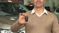 Close-up of the torso and hands of a man who picks up car keys