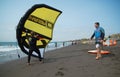 A man stands on a beach practicing with a hand held wing for hydrofoil wing surfing. Royalty Free Stock Photo