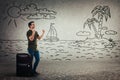 Man stands behind luggage celebrate the beginning of holiday, imagining him on a exotic island Royalty Free Stock Photo