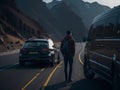 Man stands confidently between his car and van, framed by the stunning backdrop of the majestic mountains.