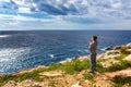 Man stands on the edge of the abyss and looks at the sea Royalty Free Stock Photo