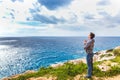 Man stands on the edge of the abyss and looks at the sea Royalty Free Stock Photo