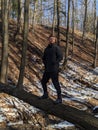 A man stands on a fallen tree over a ravine in the forest Royalty Free Stock Photo
