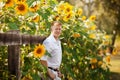 Man stands by fence near sunflowers Royalty Free Stock Photo