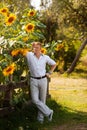 Man stands by fence near sunflowers Royalty Free Stock Photo