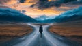 A man stands at a fork in the road, surrounded by majestic mountains under a cloudy dawn sky. Royalty Free Stock Photo