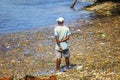 A man stands in the garbage at sea on Wasini island, Kenya. They are plastics in the Indian Ocean, Africa.