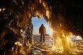 View from the ice cave with huge icicles on the frozen Lake Baikal at sunset. Royalty Free Stock Photo