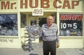 Man stands with hub cap in front of Ã¯Â¿Â½Mr. Hub CapÃ¯Â¿Â½ shop, San Jose, California