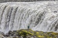 A man stands at the impressive edge of Dettifoss and looks into the torrential masses of water.