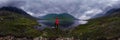 Man stands by lake in red jacket in cloudy weather. cylindrical panorama 360vr Royalty Free Stock Photo