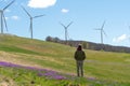 a man stands and looks at wind turbines on a sunny day Royalty Free Stock Photo