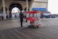 A man stands near a famous rolling chair that he pushes on the boardwalk in Atlantic City, New Jersey