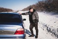 Man stands near his broken car in winter Royalty Free Stock Photo