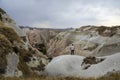 A man stands next to beautiful rocks and admires the volcanic landscape in Cappadocia in Turkey