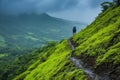 A man stands peacefully on a vibrant green hillside, surrounded by breathtaking nature, A hiker traversing slippery hill slopes Royalty Free Stock Photo