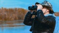 Man with binoculars looks at the river