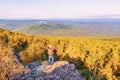 A mature male tourist stands on top of a mountain and admires the picturesque morning Ural view. Royalty Free Stock Photo