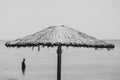 Man stands in the sea beyond unbrella Royalty Free Stock Photo